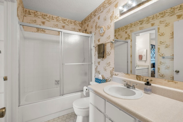 full bathroom with shower / bath combination with glass door, vanity, a textured ceiling, and toilet