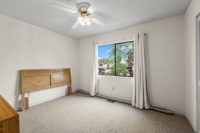 unfurnished bedroom featuring carpet flooring, a textured ceiling, and ceiling fan