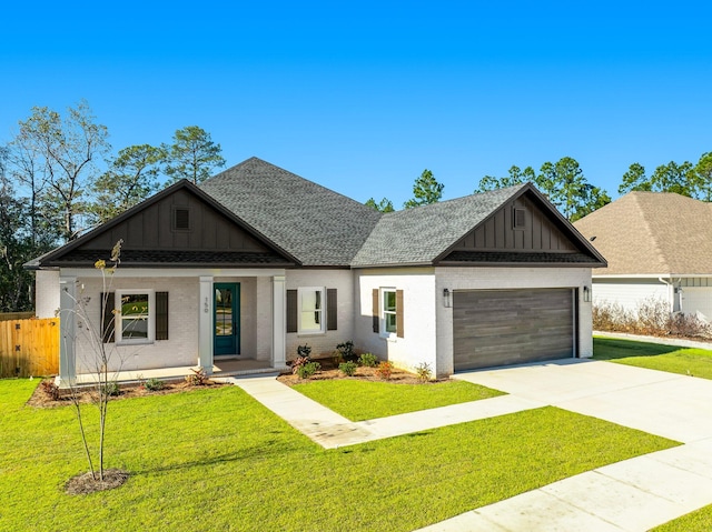 view of front of house featuring covered porch, a garage, and a front lawn