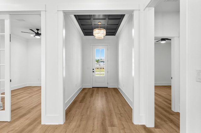 doorway with ceiling fan with notable chandelier and light wood-type flooring