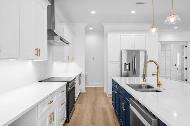 kitchen featuring blue cabinetry, sink, wall chimney exhaust hood, white cabinets, and appliances with stainless steel finishes