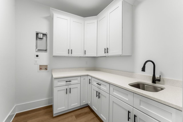 laundry area featuring cabinets, washer hookup, light wood-type flooring, electric dryer hookup, and sink