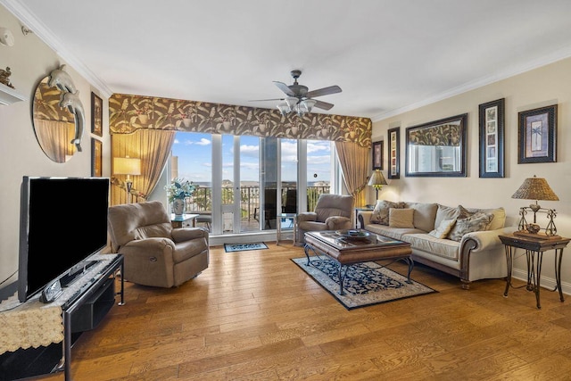 living room with hardwood / wood-style flooring, ceiling fan, and crown molding