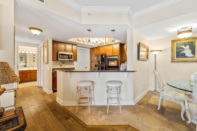 kitchen with kitchen peninsula, a kitchen bar, stainless steel appliances, light hardwood / wood-style flooring, and hanging light fixtures