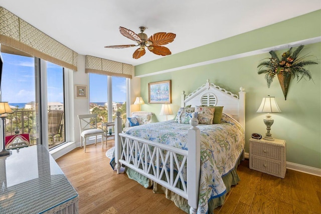 bedroom with wood-type flooring, access to outside, and ceiling fan