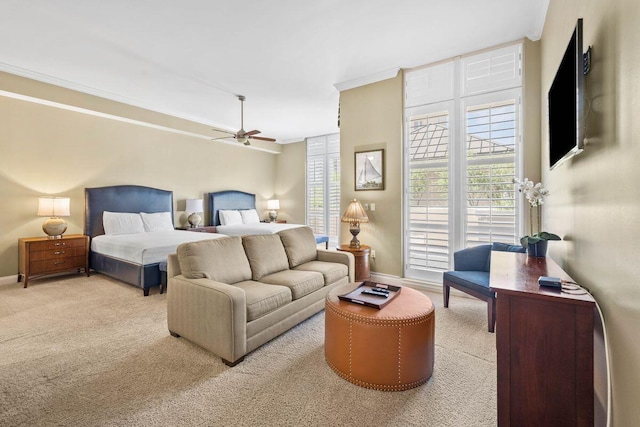 bedroom with light colored carpet, ceiling fan, and crown molding