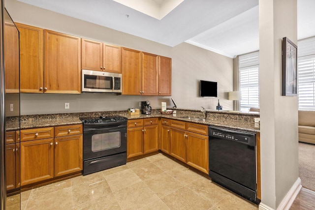 kitchen featuring sink, dark stone countertops, and black appliances