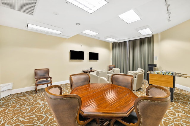 carpeted dining space featuring track lighting