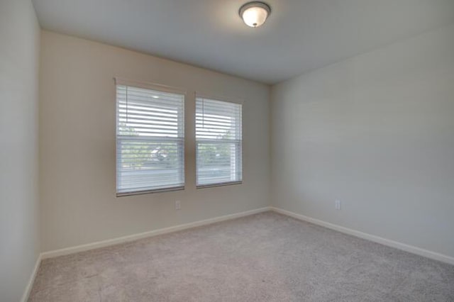 unfurnished room featuring light colored carpet