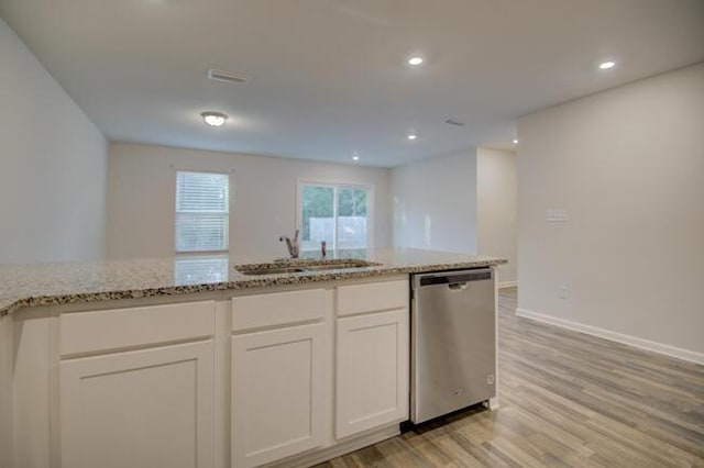 kitchen featuring light stone countertops, stainless steel dishwasher, sink, light hardwood / wood-style floors, and white cabinetry