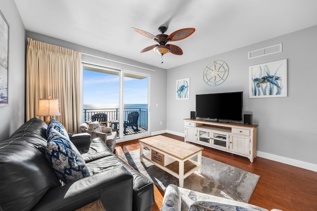 living room featuring ceiling fan and dark hardwood / wood-style flooring