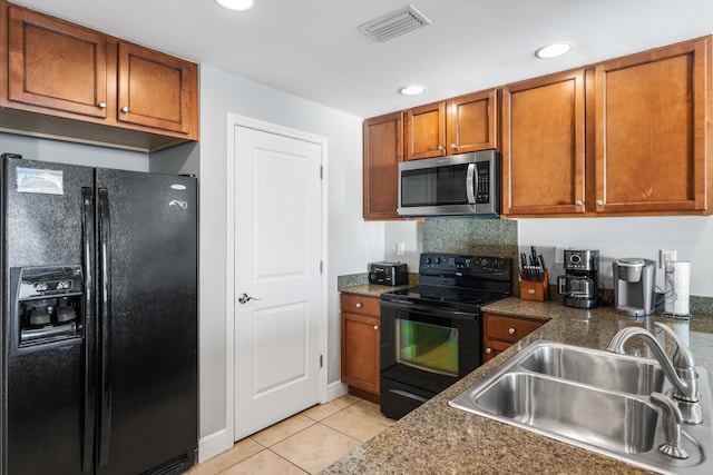 kitchen with black appliances, light tile patterned floors, sink, and dark stone counters