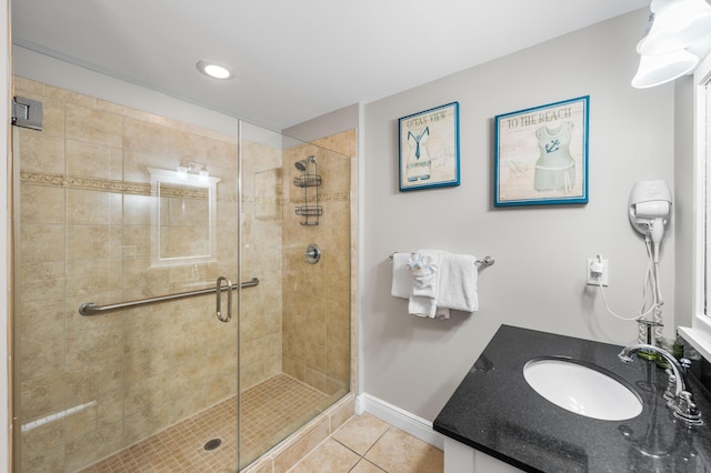 bathroom with tile patterned flooring, vanity, and walk in shower