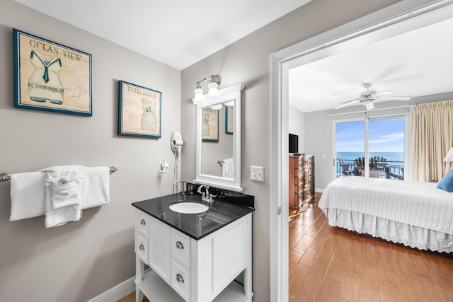 bathroom with hardwood / wood-style floors, ceiling fan, and vanity