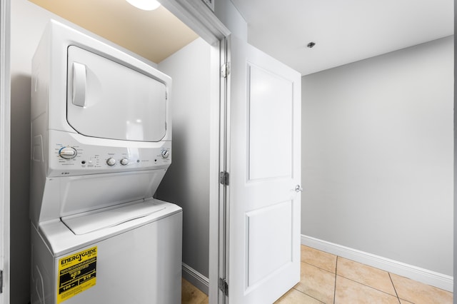 clothes washing area featuring stacked washer and dryer and light tile patterned floors