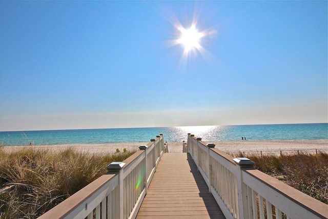 view of home's community featuring a water view and a beach view