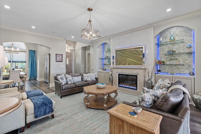 living room with an inviting chandelier, ornamental molding, and hardwood / wood-style flooring