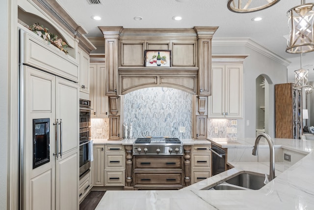 kitchen with cream cabinetry, decorative light fixtures, light stone counters, and sink