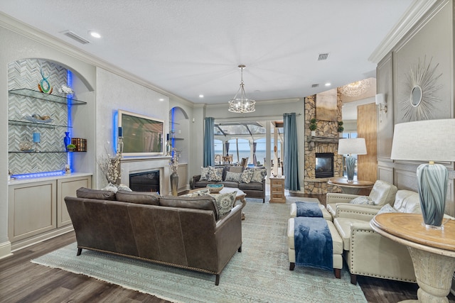 living room with hardwood / wood-style floors, a stone fireplace, ornamental molding, and a textured ceiling