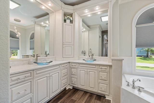 bathroom with hardwood / wood-style flooring, vanity, a bathing tub, and ornamental molding