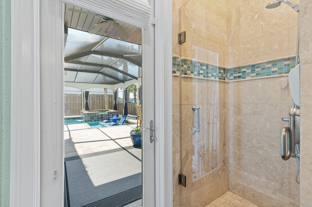 bathroom featuring a tile shower and vaulted ceiling