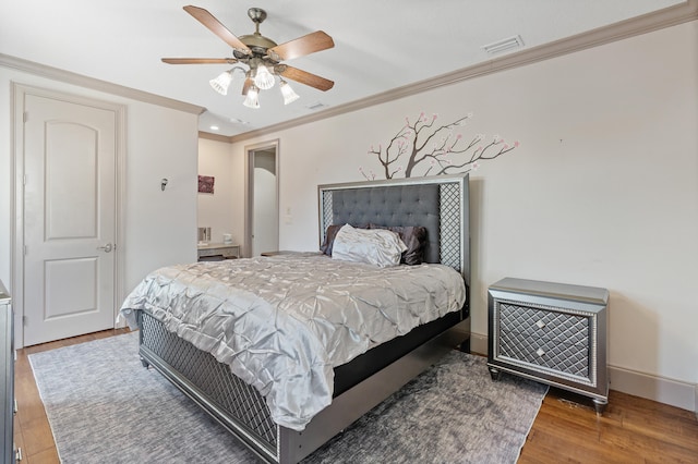 bedroom with ceiling fan, dark hardwood / wood-style floors, and crown molding