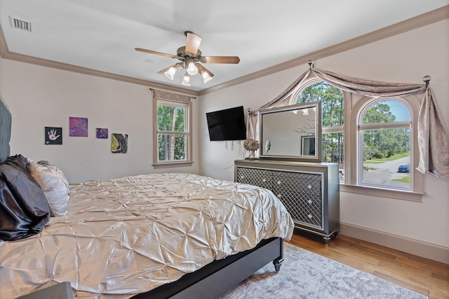 bedroom featuring hardwood / wood-style floors, ceiling fan, and ornamental molding