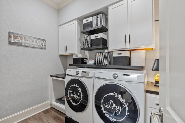 washroom with cabinets, ornamental molding, washing machine and dryer, and dark wood-type flooring