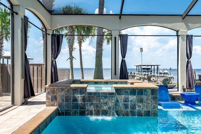 view of swimming pool with pool water feature and a water view