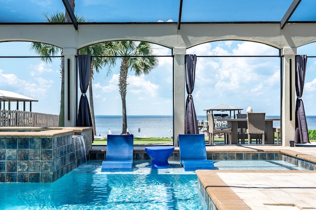 view of swimming pool with pool water feature, a water view, and a jacuzzi