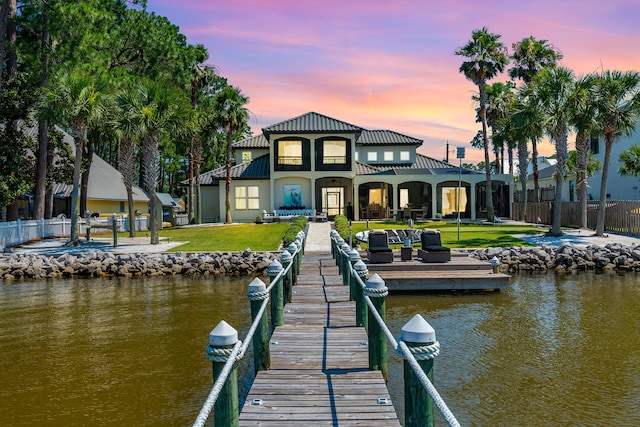 view of dock featuring a water view and a yard