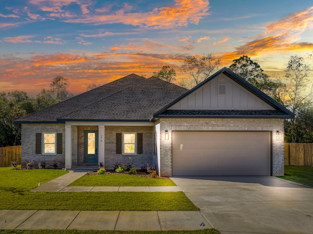 view of front of home with a garage and a lawn