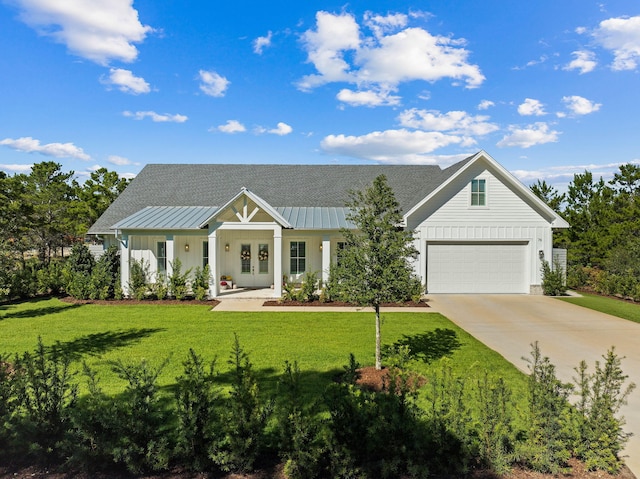 modern inspired farmhouse with a garage, a front yard, and french doors