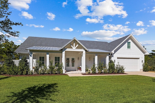 modern inspired farmhouse featuring french doors, a front yard, and a garage