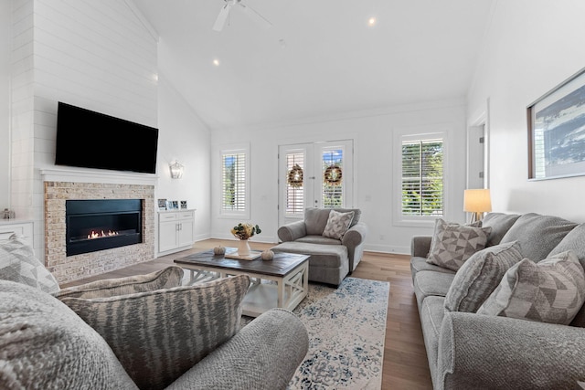 living room with ceiling fan, high vaulted ceiling, and light hardwood / wood-style floors