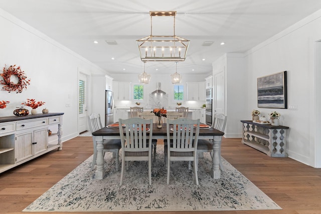 dining space featuring hardwood / wood-style flooring and ornamental molding