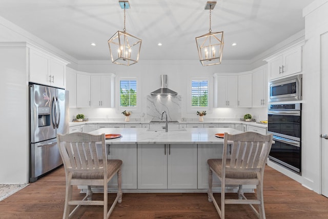 kitchen with a kitchen island with sink, hanging light fixtures, white cabinets, and stainless steel appliances