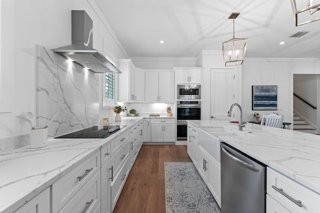 kitchen with dark wood-type flooring, wall chimney range hood, sink, appliances with stainless steel finishes, and white cabinetry