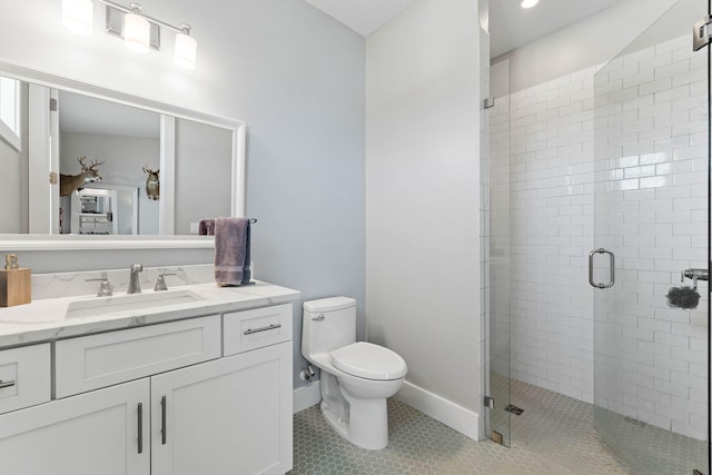 bathroom with tile patterned floors, a shower with door, vanity, and toilet