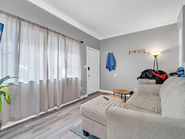 living room with crown molding and hardwood / wood-style floors