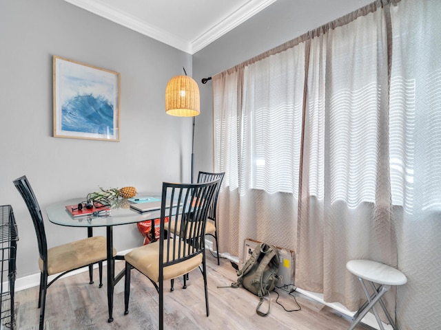 dining room with hardwood / wood-style flooring and ornamental molding