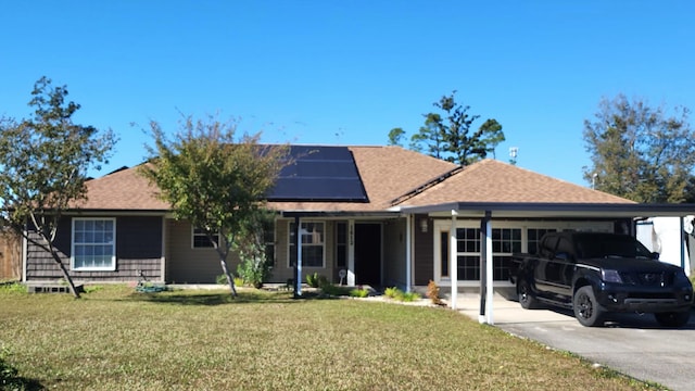 ranch-style home with a front yard, solar panels, and a carport