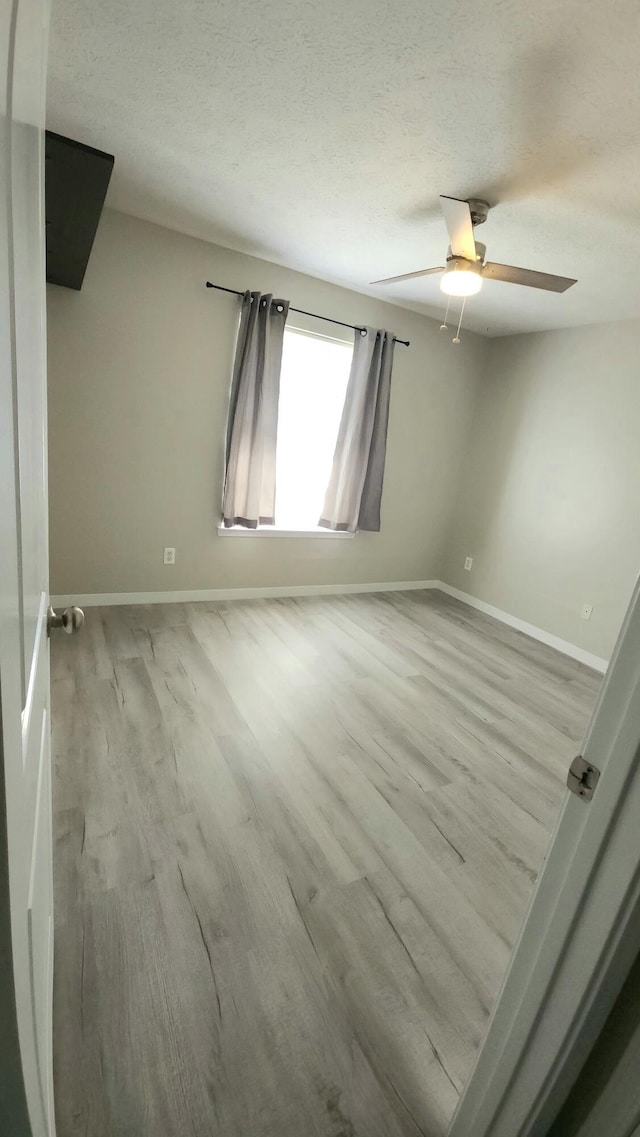 empty room featuring ceiling fan and light hardwood / wood-style flooring