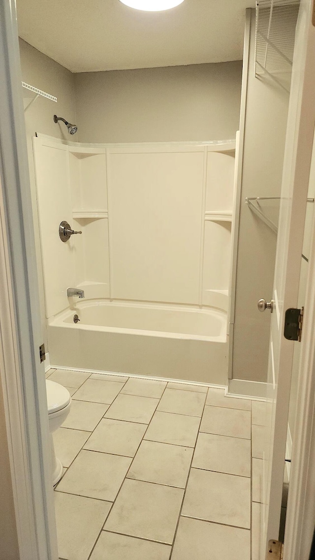 bathroom featuring tile patterned flooring, bathtub / shower combination, and toilet