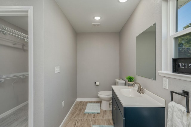 bathroom with hardwood / wood-style flooring, vanity, and toilet