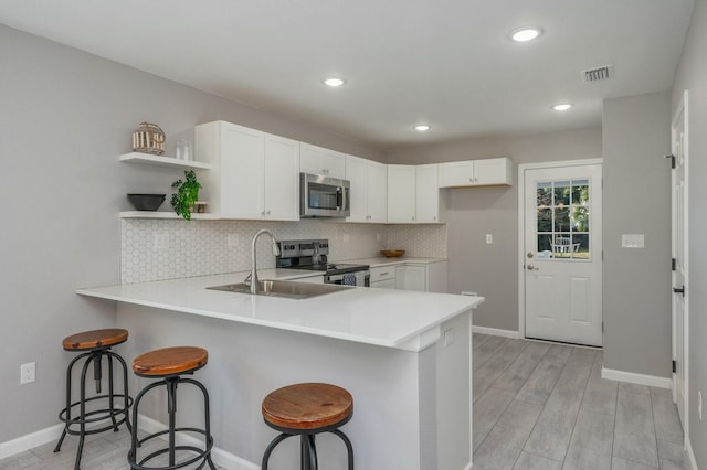 kitchen with a breakfast bar area, kitchen peninsula, and stainless steel appliances