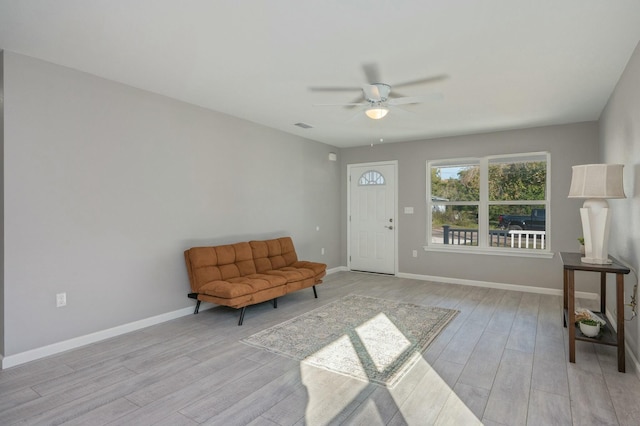 sitting room with ceiling fan and light wood-type flooring