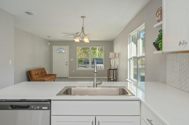 kitchen with backsplash, white cabinets, sink, hanging light fixtures, and stainless steel dishwasher