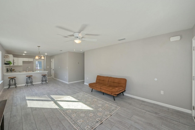 unfurnished room featuring ceiling fan, light hardwood / wood-style floors, and sink