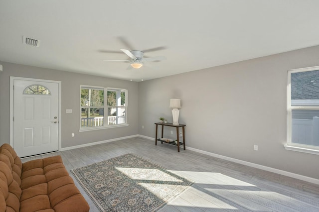 living room with light hardwood / wood-style flooring and ceiling fan